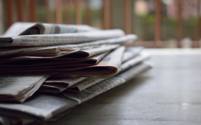 newspapers stacked on a table